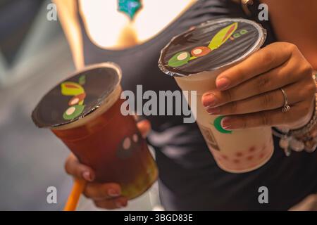 Palermo, Italien 1. Januar 2025: Frau, die zwei Bubble-Teegetränke zum Mitnehmen hält, genießt ein erfrischendes Getränk in palermo, italien Stockfoto