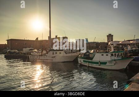 Livorno, Italien 1. Januar 2025: Fischerboote liegen im Hafen von livorno, italien, bei einem wunderschönen Sonnenuntergang Stockfoto