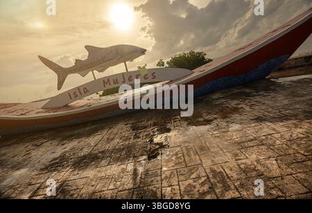 Isla Mujeres, Mexiko 1. Januar 2025: Walhai-Skulptur über einem Boot mit isla mujeres-Schild in mexiko bei einem wunderschönen Sonnenuntergang Stockfoto