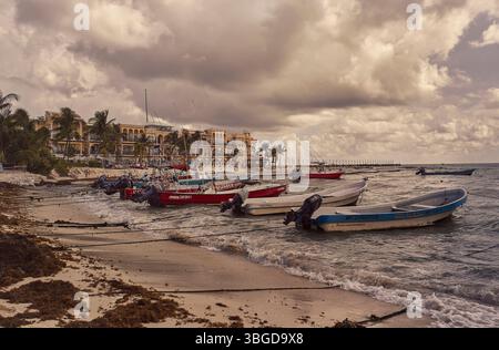 Playa del Carmen, Mexiko 1. Januar 2025: Mehrere Fischerboote liegen am Strand von playa del carmen, mexiko, mit einem Resort im Hintergrund und Stockfoto