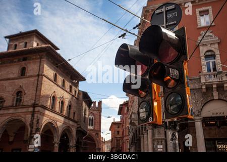 Bologna, Italien 1. Januar 2025: Ampel mit orangefarbenem Licht in bologna, italien, mit historischen Gebäuden und blauem Himmel im Hintergrund Stockfoto