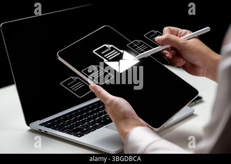 Geschäftsfrau, die ein Tablet mit einem Symbol für Rechnung und E-Mail verwendet. Laptop auf dem Tisch. Technologische Innovation auf einem virtuellen Bildschirm. Konzept von E-INVOICE und o Stockfoto