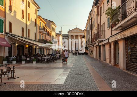Gardasee, Italien 3. Januar 2025: Touristen spazieren im Stadtzentrum von bardolino bei Sonnenuntergang, gardasee, italien Stockfoto
