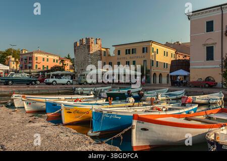 Gardasee, Italien 3. Januar 2025: Bunte Holzboote vertäuen am Pier in bardolino am gardasee. Italien Stockfoto