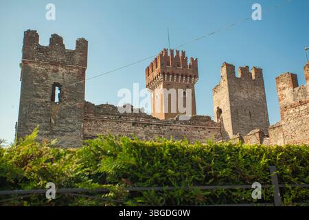 Gardasee, Italien 3. Januar 2025: Die imposanten mittelalterlichen Mauern und Türme der Burg Lazise stehen hoch vor dem klaren blauen Himmel und schaffen eine malerische landschaft Stockfoto