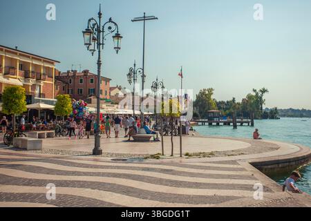 Gardasee, Italien 3. Januar 2025: Menschen genießen einen sonnigen Sommertag an der Strandpromenade von bardolino am gardasee in italien Stockfoto