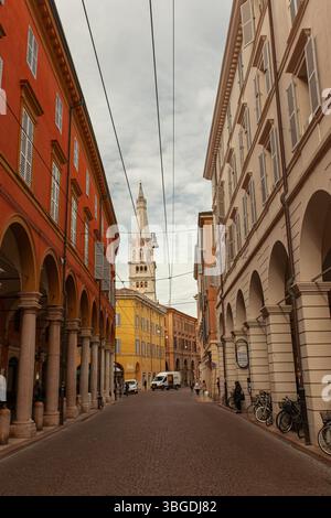 Modena, Italien 1. Januar 2025: Der Ghirlandina-Turm steht hoch über einer malerischen kopfsteingepflasterten Straße und zeigt modenas architektonische Schönheit und ita Stockfoto
