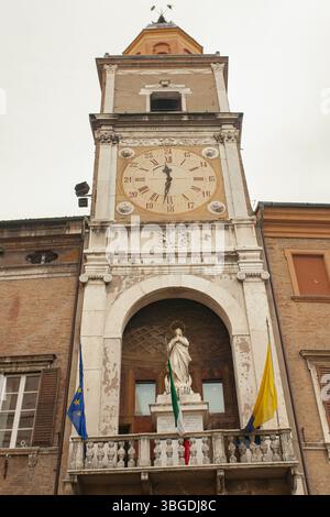 Modena, Italien 1. Januar 2025: Alter Uhrenturm mit römischen Zahlen, die Zeit, Statue und Fahnen zeigen, in modena, italien Stockfoto