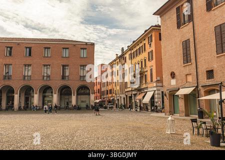 Modena, Italien 1. Januar 2025: Touristen wandern auf der piazza xx settembre in modena, italien, und genießen die bunten Gebäude und den Kopfsteinpflasterplatz Stockfoto