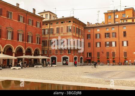 Modena, Italien 1. Januar 2025: Touristen und Bürger genießen die piazza santo stefano, einen berühmten Platz in modena, italien, umgeben von orangen Gebäuden Stockfoto