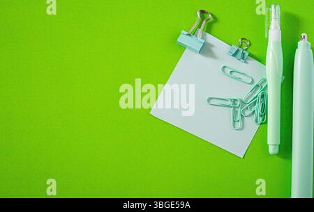 Flaches Lagen von lebendigen Schulutensilien wie Haftnotizen und Stiften auf einem farbenfrohen Hintergrund. Stockfoto