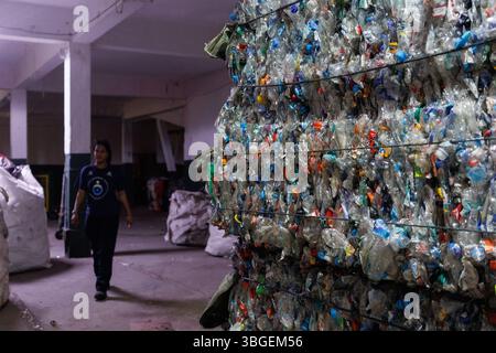 Rio De Janeiro, Brasilien. Juni 2025. Ein Arbeiter geht am 4. Juni 2025 an komprimierten Plastikflaschen vorbei, die für den Wiederverkauf in einer Recyclinggenossenschaft in Rio de Janeiro, Brasilien, bereit sind. In der nördlichen Zone von Rio de Janeiro fördern mehrere Recycling-Genossenschaften die Entwicklung einer Kreislaufwirtschaft, indem sie die Sammlung und Wiederverwendung städtischer Wertstoffe strukturiert organisieren. Quelle: Claudia Martini/Xinhua/Alamy Live News Stockfoto