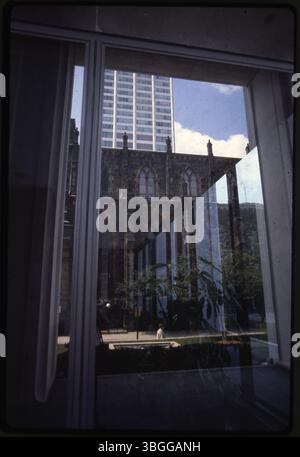 Dieses Farbfoto zeigt das Lobbyfenster des Midland Building an der 250 East Broad Street mit Blick nach Westen in Richtung St. Joseph Cathedral und Borden Building. Das Foto zeigt die Kreuzung dieser architektonischen Wahrzeichen in der Innenstadt von Columbus. Stockfoto