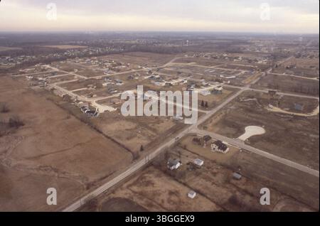 Aus der Vogelperspektive vom Februar 1981 auf die Entwicklung der Smoky Ridge Estates mit Blick nach Südosten. Die Smoky Row Road verläuft schräg über das Bild, wobei der Worthingwoods Boulevard abzweigt. Nahe gelegene Häuser am 2072 und 2084 Worthingwoods Boulevard sind sichtbar. Zwei Wassertürme und der Golfplatz Worthington Hills Country Club befinden sich im Hintergrund. Stockfoto