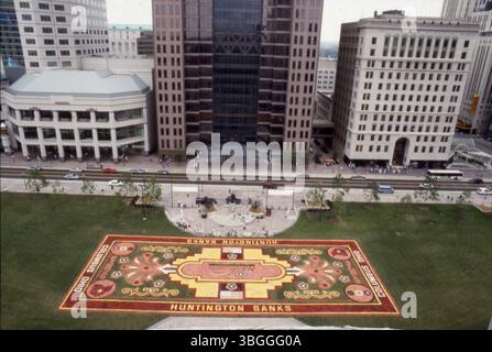 Am 26. August 1991 wurde ein belgischer Blumenteppich auf dem Ohio Statehouse Rasen ausgestellt. Die 15.000 Quadratmeter große Ausstellung zeigte rund eine halbe Million Begonienblumen. Gesponsert von der Huntington National Bank, markiert es den Start von AmeriFlora '92. Die Ausstellung war Teil einer Werbeveranstaltung, die drei Tage dauerte, mit einem Blick aus der Vogelperspektive auf das Statehouse und die umliegenden Gebäude. Stockfoto