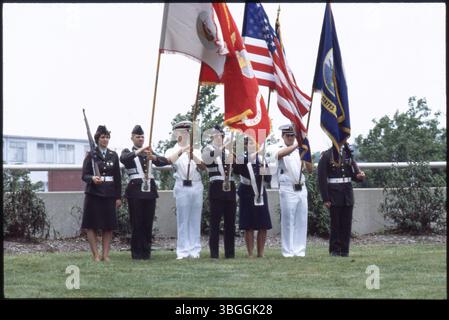 Ein siebenköpfiger Militär-Farbwächter tritt 1980 bei einer Zeremonie auf und vertritt die fünf Zweige der US-Streitkräfte: Armee, Marine, Marines, Air Force und Küstenwache. Die Mitglieder halten Fahnen und Gewehre als Teil der zeremonielle Ausstellung. Stockfoto