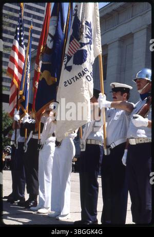 Eine militärische Farbenwache im Jahr 1980, bestehend aus acht Mitgliedern, die die fünf Zweige der United States Armed Forces repräsentierten: Army, Navy, Marines, Air Force und Coast Guard. Sechs Mitglieder halten Fahnen jeder Niederlassung und der Vereinigten Staaten, während die äußeren zwei Mitglieder Gewehre und glänzende Helme tragen. Die Wache befindet sich außerhalb des westlichen Eingangs des Ohio Statehouse. Stockfoto