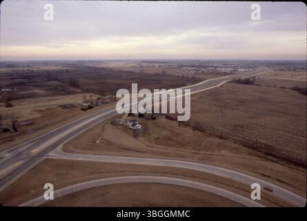 Eine Luftaufnahme der Georgesville Road im Februar 1981 mit Blick nach Süden über landwirtschaftliche Felder in der Nähe der Kreuzung I-270. Das Foto zeigt die Ausfahrt/Einstiegsrampen der I-270, die diagonal verlaufende Georgesville Road und die Landebahn von Bolton Field in der Ferne. Die Erschließung umfasst die Umzonierung von 57,5 Acres für die Herstellung, wie von der Entwicklungskommission empfohlen. Stockfoto