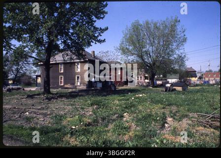Ein Blick auf nicht identifizierte Hinterhof-Grundstücke mit zwei Hundehäusern und mehreren Ersatzreifen. Das Gebiet liegt möglicherweise in der Nähe der Reeb Avenue. Stockfoto