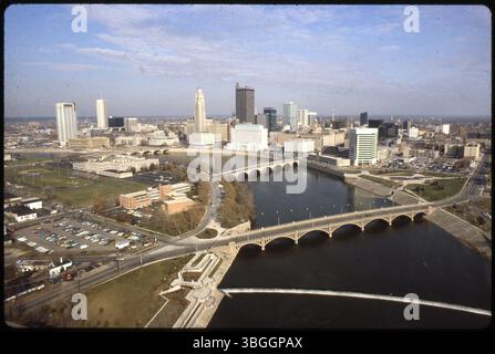 Ein Blick aus der Vogelperspektive nach Nordosten über Franklinton und die Innenstadt von Columbus, geteilt durch den Scioto River. Bemerkenswerte Brücken erstrecken sich über den Fluss, darunter die Broad Street Bridge, die Town Street Bridge und die Main Street Bridge. Zu den sichtbaren Gebäuden gehören die Central High School, das Columbus Health Department Building, das AEP Building im Bau und mehrere Regierungsgebäude, darunter das Joseph P. Kinneary Courthouse und das Columbus City Hall. Stockfoto