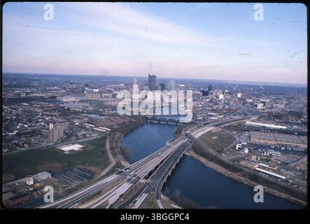 Ein Blick aus der Vogelperspektive von 1978 nach Nordosten zeigt Franklinton, die Innenstadt von Columbus und einen Teil des Brewery District. Das Foto wurde oberhalb der Kreuzung der Interstates 70 und 71 und der Ohio Route 315 aufgenommen. Der Scioto-Fluss führt durch das Zentrum. Hertz Truck Rental an der 669 Sullivant Avenue ist links unten zu sehen, und das A&P Warehouse, früher Chesapeake Storage Company an der 349 West Mound Street, befindet sich rechts unten. Stockfoto
