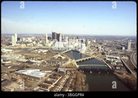 Ein Blick aus der Vogelperspektive aus dem Jahr 1987 in nordöstlicher Richtung von Franklinton und der Innenstadt von Columbus, mit dem Scioto River dazwischen. Broad Street, Town Street, Main Street und Eisenbahnbrücken überqueren den Fluss. Auf der Westseite des Flusses befinden sich die Riverside-Bradley Apartments, und die Interstate 70 verläuft auf der rechten Seite entlang, parallel zur Mound Street. Stockfoto