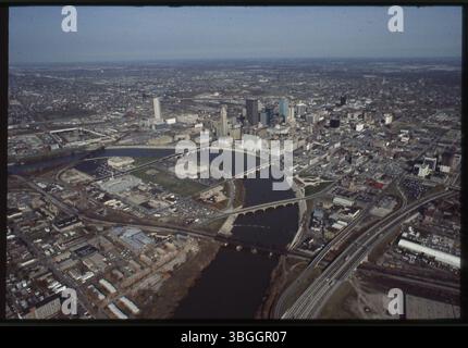 Ein Blick aus der Vogelperspektive von ca. 1977 nach Nordosten über Franklinton und die Innenstadt von Columbus, geteilt durch den Scioto River. Bemerkenswerte Gebäude sind die Franklin County Veterans Memorial Hall, die Godman Shoe Company, die Central High School und das Columbus Health Department. Stockfoto