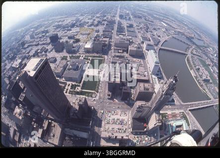 Ein Blick aus der Vogelperspektive von 1976 nach Süden über den südlichen Teil der Innenstadt von Columbus. Die South High Street verläuft vertikal durch die Bildmitte, wobei die Broad Street den Scioto River überquert. Der James A. Rhodes State Office Tower und der Leveque Tower sind die höchsten Gebäude, wobei das Ohio Statehouse auch südlich des Rhodes Tower sichtbar ist. Stockfoto