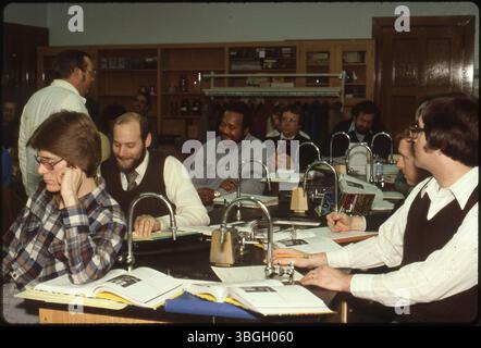 Ein Wissenschaftskurs von 1971 wird mit mehreren Labortischen mit Waschbecken gezeigt. Mindestens 11 Schüler sind sichtbar, und ein Mann mit Brille, wahrscheinlich der Professor, steht im Hintergrund. Stockfoto