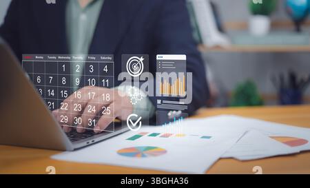 Hand-auf-Laptop mit digitalem Kalender, Ziel, Karten. Symbolisiert digitale Planung, Projektplanung und Zielsetzung. Ideal für die Unternehmensführung, PR Stockfoto