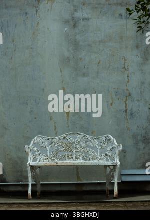 Eine gruselige, allein rostige Bank in einem verlassenen Spukgarten. Stockfoto