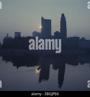 Ein Morgenblick auf die Skyline von Columbus mit einem Kanu, das bei Sonnenaufgang auf dem Scioto River gleitet, bietet eine ruhige Stadtlandschaft. Stockfoto