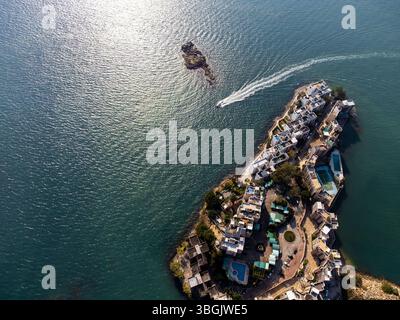 Atemberaubende Drohnenaufnahme einer Wohninsel in Tuen Mun, Hongkong, mit Häusern am Wasser, üppigem Grün und klarem blauem Wasser. Stockfoto