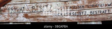 Verblasste deutsche Schrift auf verwitterten Holzbrettern vor dem verlassenen Sporthotel Paradiso al Cevedale, ein alpines architektonisches Relikt von Gio Ponti, Martelltal, Autonome Provinz Bozen, Südtirol Stockfoto