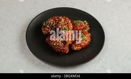 Köstlich glasierte Chicken Wings mit Sesam und grüner Zwiebelgarne Stockfoto