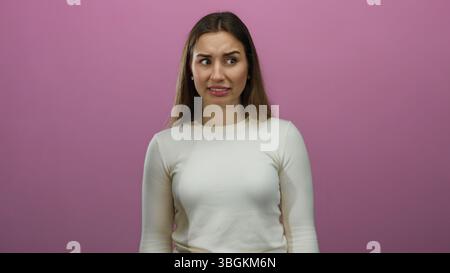 Frau, die verschiedene Emotionen vor einer isolierten rosafarbenen Hintergrundwand ausdrückt, die eine Reihe von Gesichtsausdrücken zeigt, einschließlich Verwirrung und Frustrat Stockfoto