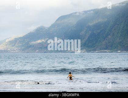 SEIXAL, MADEIRA, PORTUGAL - 25. APRIL: Eine junge Frau schwimmt im Meer gesehen am 25. April 2025 in Seixal, Madeira, Portugal. Stockfoto