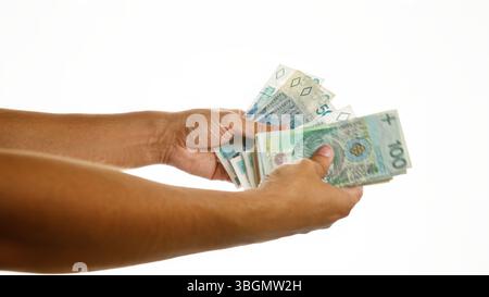 Mann, der polnische Zloty-Banknoten vor einem isolierten weißen Hintergrund hält, was Finanztransaktionen in polen veranschaulicht Stockfoto