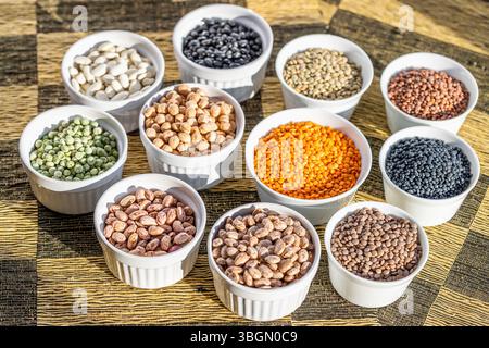 Getrocknete Hülsen, weiße Bohnen, schwarze Bohnen, Kichererbsen, Tellerlinsen, Berglinsen, grüne Erbsen, Wachtelbohnen, rote Linsen, Belugalinsen, Borlotti-Bohnen Stockfoto