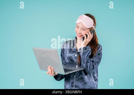 Asiatisch tragender Pyjama Unternehmer Notebook Social Lady, die online arbeitet, Eine junge Geschäftsfrau im lässigen Stil mit Laptop für Arbeit und Studium in einem Mod Stockfoto