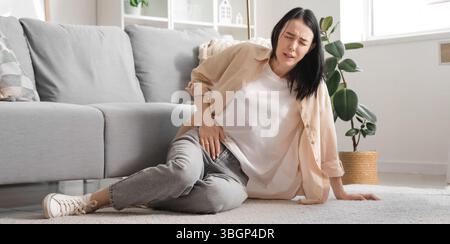 Junge Frau mit starken Bauchschmerzen zu Hause Stockfoto