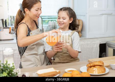 Gemeinsame Aktivitäten während der Feiertage. Mutter und Tochter essen in den Ferien zusammen. asiatische Frauen bereiten Frühstück am Morgen zu Stockfoto