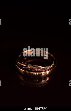 Minimalistisches Design aus goldenem Diamantring mit glänzenden Steinen in dramatischer Kontrastbeleuchtung – ideal für Premium-Produktpräsentationen oder Hochzeitsthemen Stockfoto