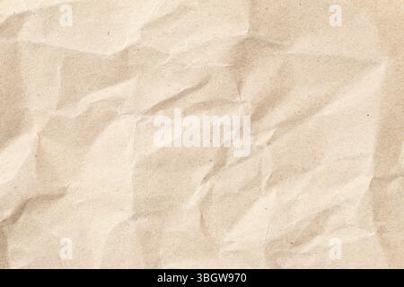 Nahaufnahme der zerknitterten beigen Papierstruktur. Ideal für Designprojekte, Hintergründe oder künstlerische Kreationen, die ein natürliches und Vintage-Feeling benötigen. Stockfoto