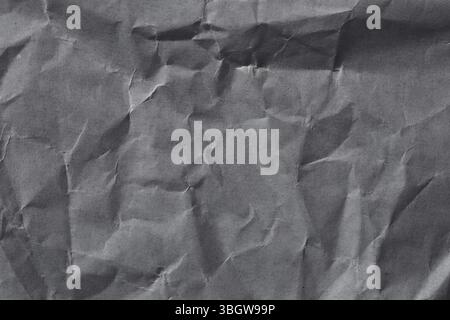 Nahaufnahme des zerknitterten grauen Papiers mit einzigartiger Textur und Mustern. Ideal für Hintergründe oder kreative Designprojekte. Stockfoto