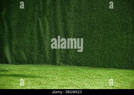 Textur von künstlichem Grüngras-Zaunmaterial als Hintergrund, Nahaufnahme Stockfoto