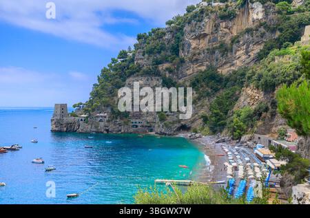 Der schönste Strand in Positano in Italien: Blick auf den Strand von Fornillo, der aus Sand mit Kieselsteinen und leichtem Kies mit einem Wachturm besteht. Stockfoto