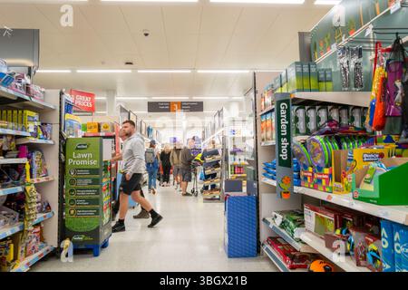 Kunden, die einen Gang in einem Sainsburys-Geschäft in Großbritannien entlang laufen. Stockfoto