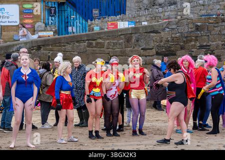 Teilnehmer treffen sich am Strand von Towan und bereiten sich auf die jährliche Veranstaltung „Superheld in the Cold“ vor, um Mittel für Cancer Research UK zu sammeln. Stockfoto