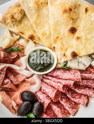 Eine wunderschön arrangierte Artisan Charcuterie Platte mit frischen Zutaten und Saucen Stockfoto